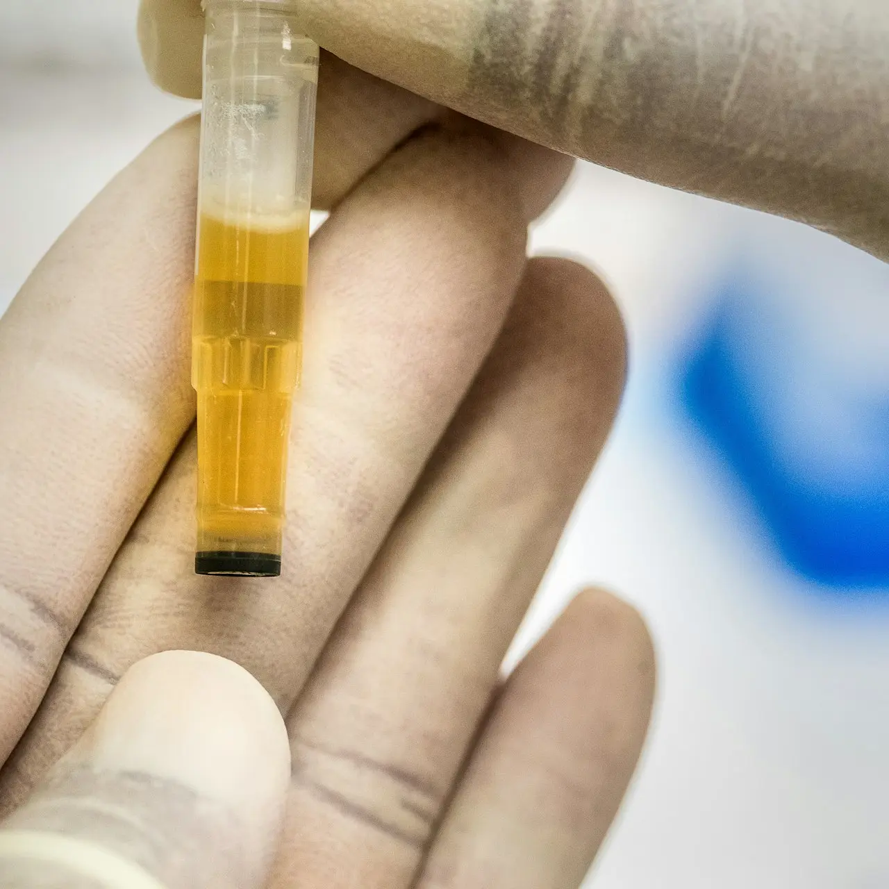 person holding yellow and clear tube
